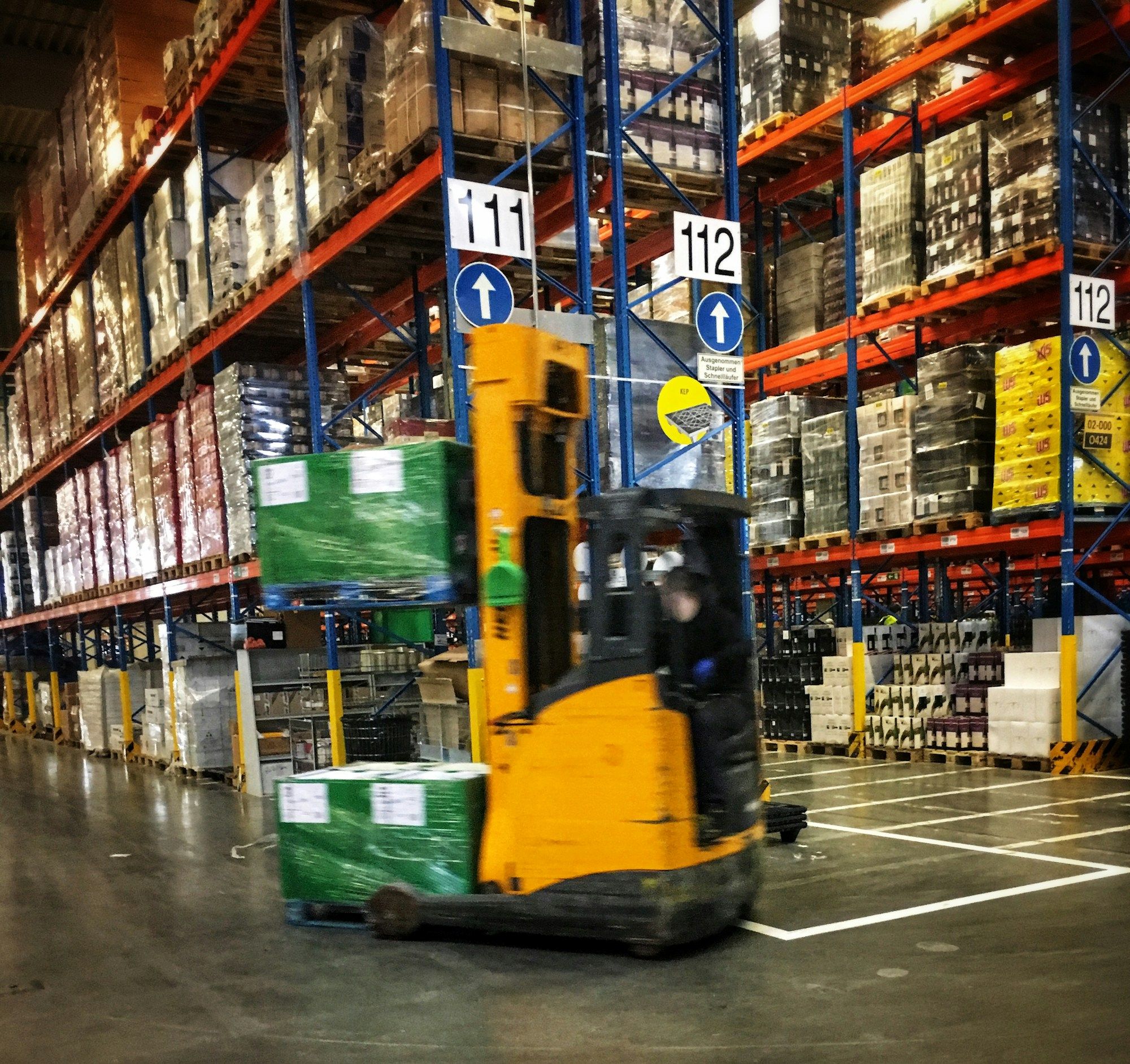 Forklift working between pallet racking in a warehouse