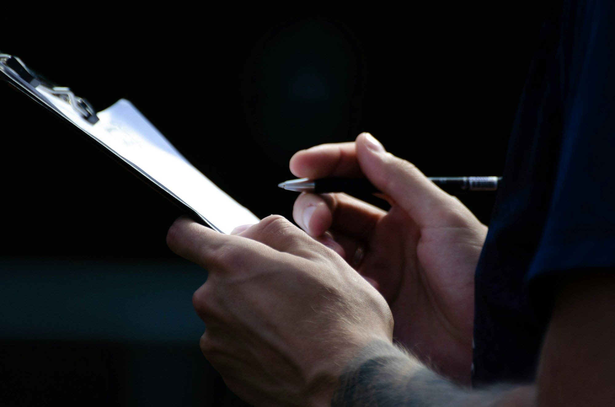 Hand signing off a document on a clipboard