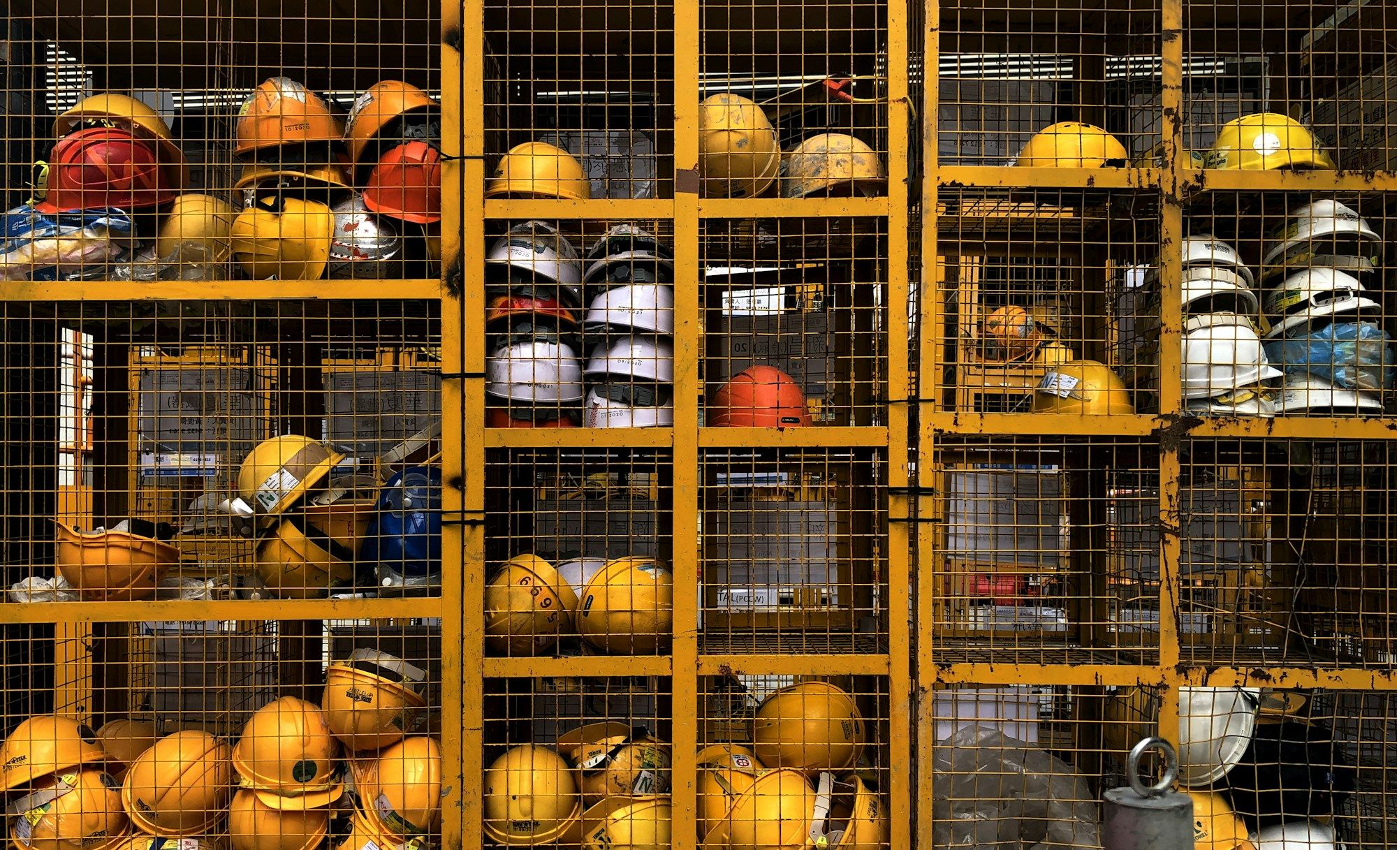 Rows of safety helmets stored in a site cage