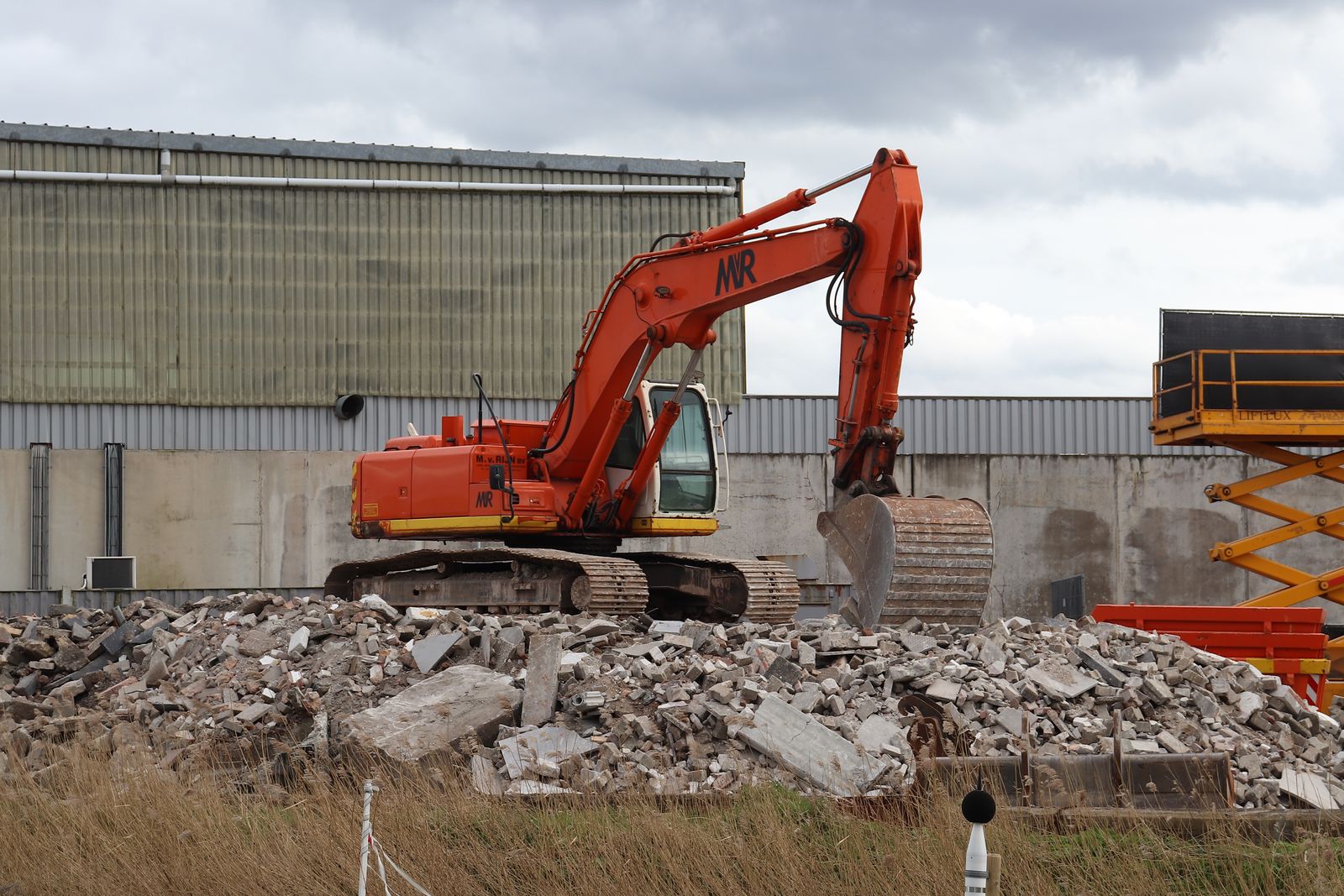 Excavator working on a pile of demolition rubble